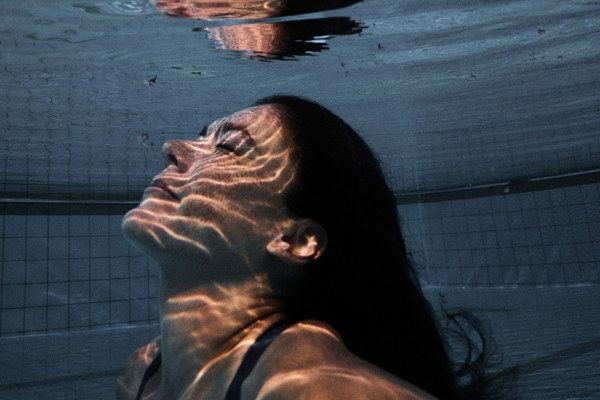 Frau unter Wasser mit dem Blick Richtung Wasseroberfläche